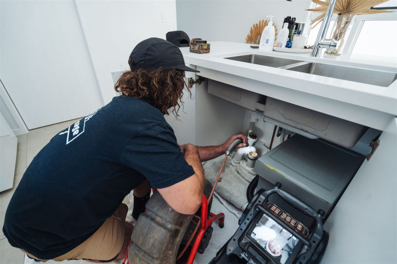 An image of the Dizzys Drainage team working on a pipe