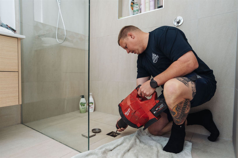 An image of a Dizzys Drainage team member working on a bathroom